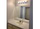 Bathroom vanity with sink, mirror, and cabinet storage, complemented by a stylish lighting fixture at 14001 Fairway Island Dr # 513, Orlando, FL 32837