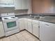 Efficient kitchen featuring white cabinets, stove, dishwasher and tile flooring at 14001 Fairway Island Dr # 513, Orlando, FL 32837