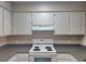 Bright kitchen with white cabinets, dark countertops, stove, and overhead lighting at 14001 Fairway Island Dr # 513, Orlando, FL 32837