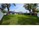 A serene backyard with lush green grass, enclosed by a white fence and wooden fencing, perfect for relaxation at 1412 Pine St, Orlando, FL 32824