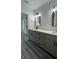 Modern bathroom featuring double vanity, updated fixtures, decorative plant and stylish gray vinyl plank flooring at 1412 Pine St, Orlando, FL 32824