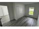 Bright bedroom featuring natural light, closet with bi-fold doors and stylish gray vinyl plank flooring at 1412 Pine St, Orlando, FL 32824