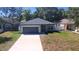 Charming single-story home featuring a gray exterior, a two-car garage, and a well-maintained front yard at 1412 Pine St, Orlando, FL 32824