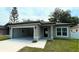Charming single-story home featuring a gray exterior, a two-car garage, and a well-maintained front yard at 1412 Pine St, Orlando, FL 32824