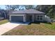 Charming single-story home featuring a gray exterior, a two-car garage, and a well-maintained front yard at 1412 Pine St, Orlando, FL 32824