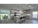 Modern kitchen with island seating, gray cabinets, stainless steel appliances, and dining area at 1412 Pine St, Orlando, FL 32824