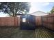 Backyard shed with a window nestled beside a wooden fence, providing secure storage and privacy at 14120 Rutgers Ave, Orlando, FL 32826