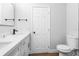 This bathroom includes double sink vanity with modern fixtures, a white door and a toilet at 14120 Rutgers Ave, Orlando, FL 32826
