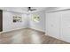 Bright bedroom featuring wood-look floors, two windows, a ceiling fan, and a closet at 14120 Rutgers Ave, Orlando, FL 32826