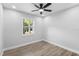 This bedroom has a window with view of the exterior, neutral walls, light wood floors and ceiling fan at 14120 Rutgers Ave, Orlando, FL 32826
