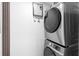 Modern laundry area with stacked washer and dryer, and a tankless water heater at 14120 Rutgers Ave, Orlando, FL 32826
