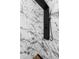 Close-up of a sleek, modern shower with marble-style tiling and a black shower system at 14120 Rutgers Ave, Orlando, FL 32826