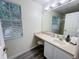 Bathroom with a single vanity, stool, and a large mirror; good light at 143 Windsor Pl, Davenport, FL 33896
