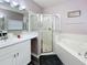 Modern bathroom featuring a soaking tub, separate shower, and stylish vanity with marble counters at 143 Windsor Pl, Davenport, FL 33896