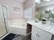 Modern bathroom featuring a soaking tub, separate shower, and stylish vanity with marble counters at 143 Windsor Pl, Davenport, FL 33896