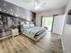 Bright bedroom featuring modern wood floors, ceiling fan, and a striking black and white city mural at 143 Windsor Pl, Davenport, FL 33896