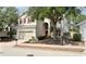 Charming two-story home with red shutters, a well-manicured lawn and a brick driveway at 143 Windsor Pl, Davenport, FL 33896