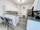 Well-lit kitchen with gray-toned flooring, white cabinets, and stainless steel appliances at 143 Windsor Pl, Davenport, FL 33896