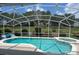 Inviting pool area with screened enclosure, including a spa, lush landscaping, and a peaceful backyard setting at 143 Windsor Pl, Davenport, FL 33896