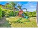 Landscaped backyard with a well-maintained lawn and a wooden playset at 14518 Black Quill Dr, Winter Garden, FL 34787