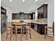 Modern kitchen boasts dark cabinetry, stainless steel appliances, and a center island with bar stool seating at 14518 Black Quill Dr, Winter Garden, FL 34787