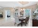 Formal dining room with elegant chandelier, tray ceiling, and large windows showcasing natural light at 1525 Eagle Nest Cir, Winter Springs, FL 32708