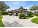 Exterior side view of the home featuring a large driveway and two garage doors framed by manicured bushes at 1525 Eagle Nest Cir, Winter Springs, FL 32708