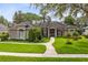 Stunning single-story home featuring a manicured lawn, mature trees, and a welcoming walkway leading to the front entrance at 1525 Eagle Nest Cir, Winter Springs, FL 32708