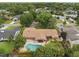 Aerial view of a home with a pool, patio, lush landscaping, mature trees, and a privacy fence at 1618 Pepperidge Dr, Orlando, FL 32806