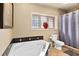 Bright bathroom featuring a large soaking tub with black tile trim, a window and a separate shower at 1618 Pepperidge Dr, Orlando, FL 32806
