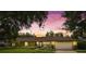 Charming ranch-style home with well-manicured lawn and mature trees in a tranquil setting at dusk at 1618 Pepperidge Dr, Orlando, FL 32806