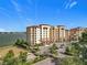 Aerial view of condo building, parking lot, landscaping, and lake in the distance on a beautiful day at 16300 County Road 455 # 405, Montverde, FL 34756