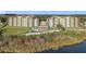 Aerial view captures the condo building next to a lake, and amenities including a pool, overlooking the tranquil waters at 16300 County Road 455 # 405, Montverde, FL 34756