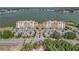 Wide aerial shot of lakeside condo complex features a well-maintained parking area, lush landscaping, and stunning views at 16300 County Road 455 # 405, Montverde, FL 34756