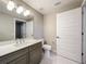 Well-lit bathroom with a gray vanity, quartz countertop, and a view to the toilet space for a luxurious feel at 16300 County Road 455 # 405, Montverde, FL 34756