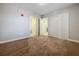 Neutral bedroom with three white doors, a brown carpet and a red fire-safety-sprinkler cap at 16300 County Road 455 # 405, Montverde, FL 34756