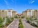 Stunning exterior view of a resort-style condo community, featuring lush landscaping and Mediterranean architecture at 16300 County Road 455 # 405, Montverde, FL 34756