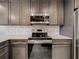 Updated kitchen features stainless steel appliances, backsplash, gray cabinets, and light countertops at 16300 County Road 455 # 405, Montverde, FL 34756