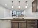 Open kitchen with stainless steel dishwasher, dark cabinets, light countertops, and a view to living spaces at 16300 County Road 455 # 405, Montverde, FL 34756