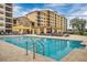 Stunning community pool area features crystal clear water, lounge chairs, and the architecture of the beautiful building at 16300 County Road 455 # 405, Montverde, FL 34756