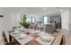 Open-concept dining area flowing into the living room and kitchen, featuring a set table and modern decor at 167 Amberwood Way, Umatilla, FL 32784