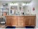 Bright bathroom with a double vanity, granite counters, decorative mirrors and modern sinks at 20446 Macon Pkwy, Orlando, FL 32833