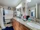Bathroom showcasing double sinks with granite counters, decorative mirrors, storage, and a view at 20446 Macon Pkwy, Orlando, FL 32833