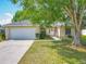 Charming single-story home with a well-maintained lawn, mature tree, and inviting curb appeal at 20446 Macon Pkwy, Orlando, FL 32833