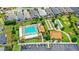 Aerial view showcases a community pool with bocce ball courts, surrounded by lush landscaping and ample parking at 2086 Biller Cir, The Villages, FL 32163