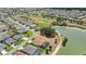Aerial view showcases lakefront homes next to a golf course with lush greenery in a well-maintained neighborhood at 2086 Biller Cir, The Villages, FL 32163