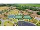 Aerial view of tennis and pickle ball courts, a soccer field, and a park with lush landscaping at 2086 Biller Cir, The Villages, FL 32163