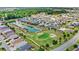 An aerial view features new construction homes bordering a well-manicured golf course and pond at 2086 Biller Cir, The Villages, FL 32163