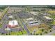 Aerial view of a vibrant commercial district with stores, restaurants, and gas stations amid lush landscaping at 2086 Biller Cir, The Villages, FL 32163