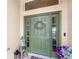Inviting front entrance with an olive green door, decorative wreath, and sidelights, enhancing curb appeal at 2086 Biller Cir, The Villages, FL 32163
